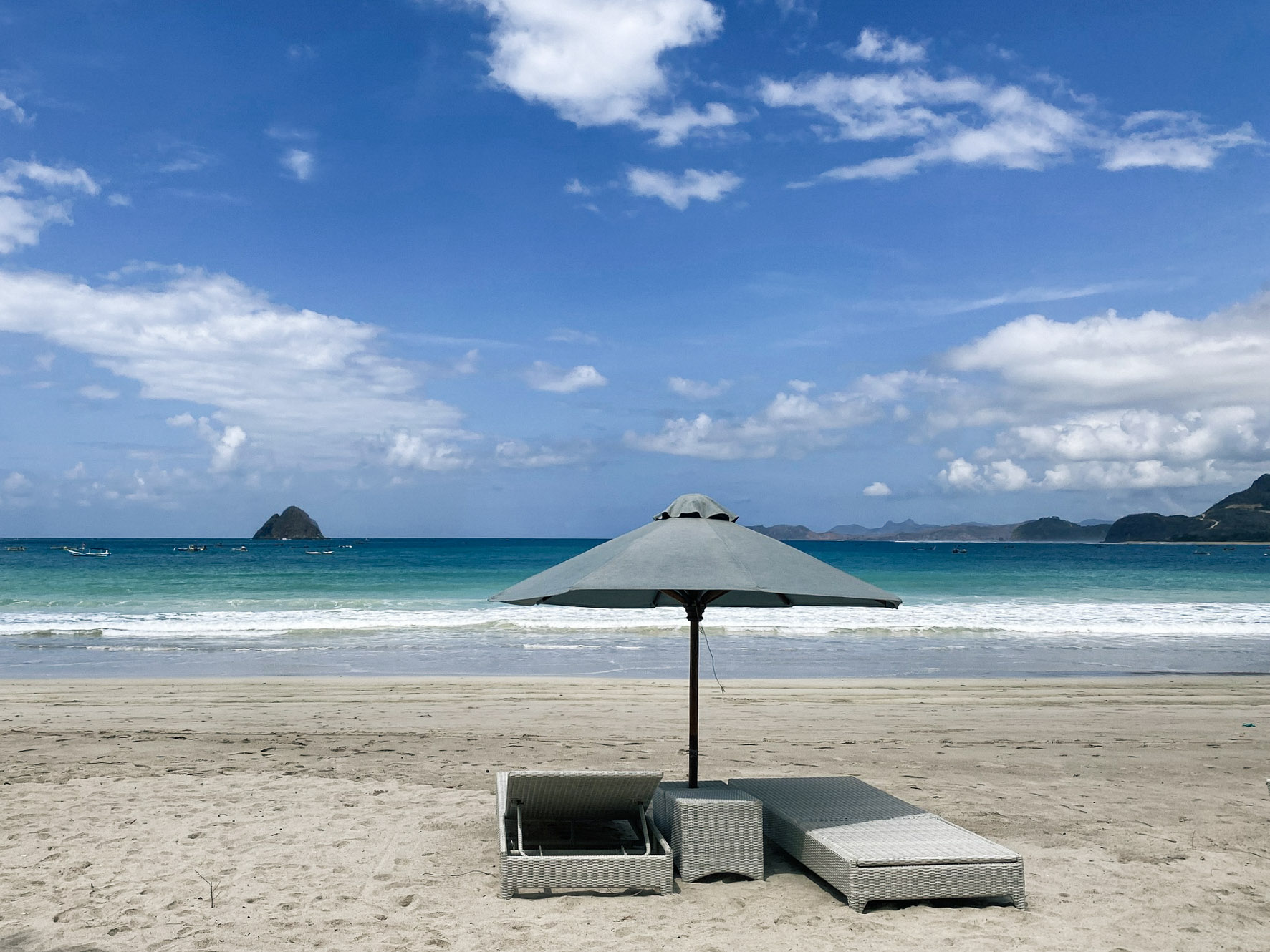 Sun loungers and a beach umbrella on Selong Belanak Beach, Lombok, Indonesia.