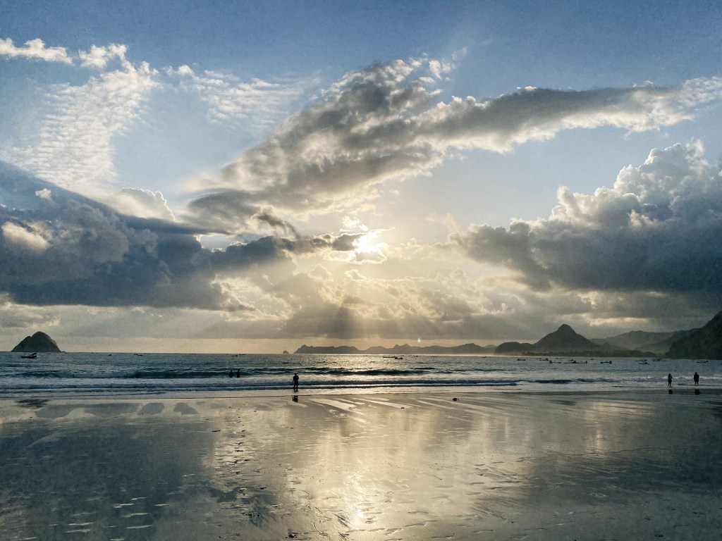 Reflections of the sky on the wet sand at Selong Belanak Beach, Lombok, Indonesia.